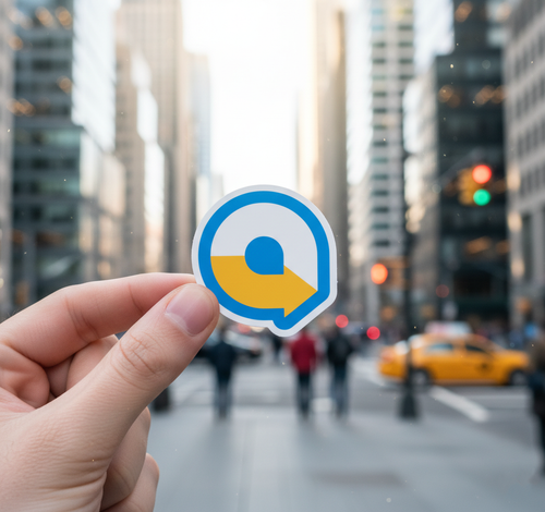 Hand holding a sticker with a blue and yellow logo against a city street background